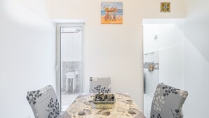 A dining area with a table, chairs, and a view of the outside. - Apartment 'Dafne Home' with Wi-Fi and Air Conditioning (Siracusa)