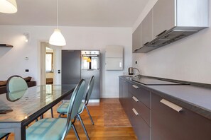Una cocina moderna con comedor, electrodomésticos de acero inoxidable y una mesa de vidrio.