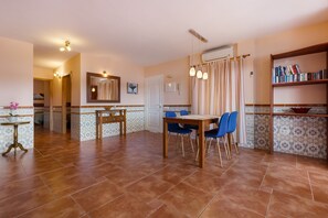 Une cuisine spacieuse avec un coin repas, une bibliothèque et une salle de bain visible au fond.