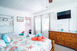 Una camera da letto con un letto, una cassettiera, una televisione e una finestra.