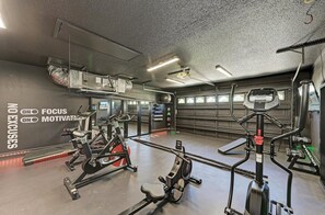 Ein Fitnessstudio mit unterschiedlichen Trainingsgeräten, einer Spiegelwand und motivierenden Texten an der Wand.