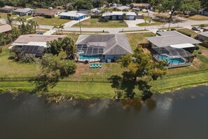 A residential area with houses, a swimming pool, and a body of water. - Waterfront Heated Pool | AMI • Siesta • IMG (Sarasota)
