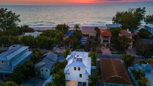 Una zona residenziale sul lungomare, con case e vista sull'oceano al tramonto.
