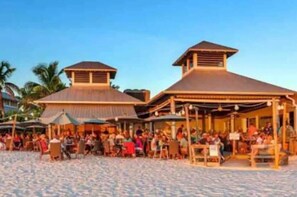 Un restaurante frente a la playa con terraza y zona cubierta.