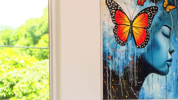 A painting of a woman's face with a butterfly on the wall. - Spacious 5-bedroom house in welcoming Managua with WiFi, AC (Managua)