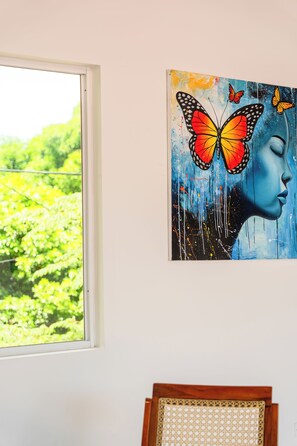 Un tableau représentant le visage d’une femme, avec un papillon sur le mur.