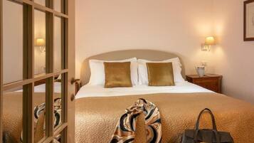 Une chambre d’hôtel avec un lit, une table de chevet et une lampe.