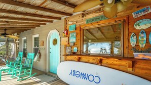 Un restaurant à thème balnéaire, avec des chaises turquoise, un panneau en forme de planche de surf et une décoration en bois.