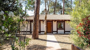 A building with a tiled roof, a wooden door, and a brick pathway leading to it. - Villas Indigo, Villa(s) Indigo proches des plages (La Teste-de-Buch)