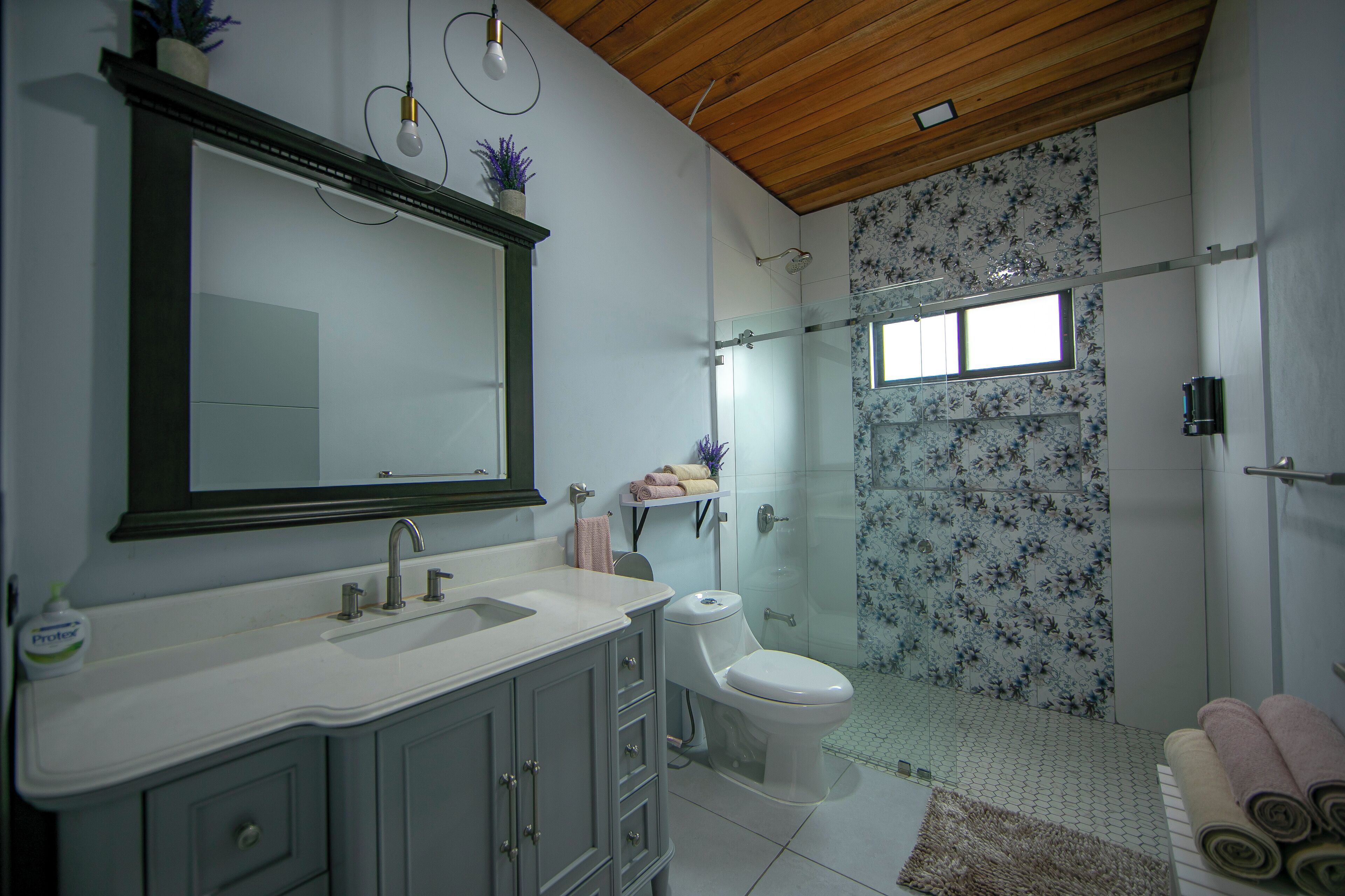 Une salle de bain comprenant un lavabo, des toilettes et un espace douche.