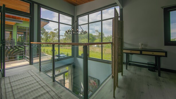 A spacious room with large windows, a wooden ceiling, and a modern chandelier. - Casa Azulada-King beds, pool, BBQ, parking on property, 5 min to LaFortuna! (La Fortuna)