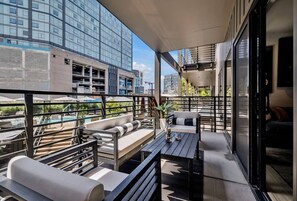 A modern outdoor seating area with a pool, a staircase, and a view of the cityscape. - The Gibson Stage Combo Downtown, Pool/Gym/Parking, Walk to Broadway (Nashville)