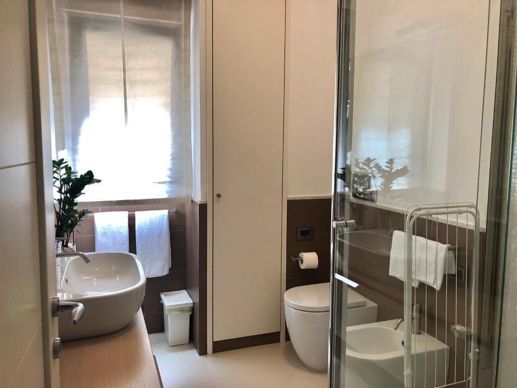 Une salle de bain moderne avec un grand lavabo, des toilettes et une douche à parois de verre.