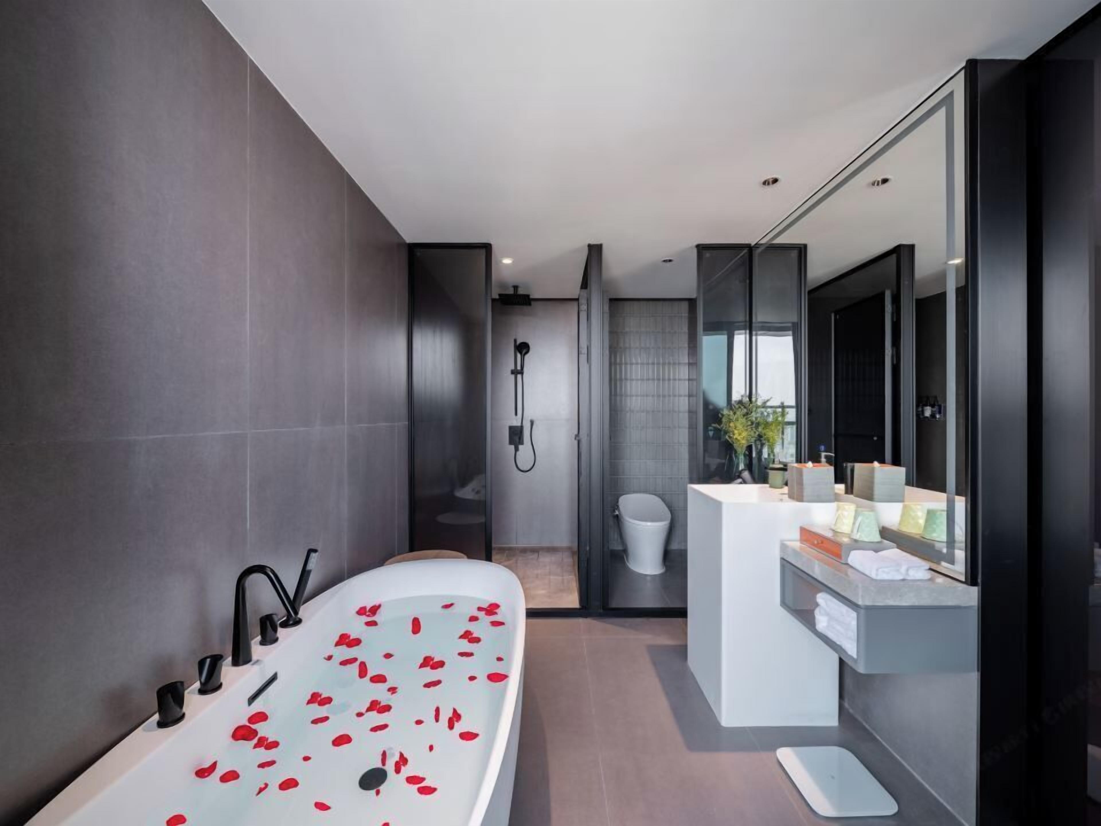 Ein modernes Badezimmer mit freistehender Badewanne, Dusche und Waschtisch mit Spiegel.