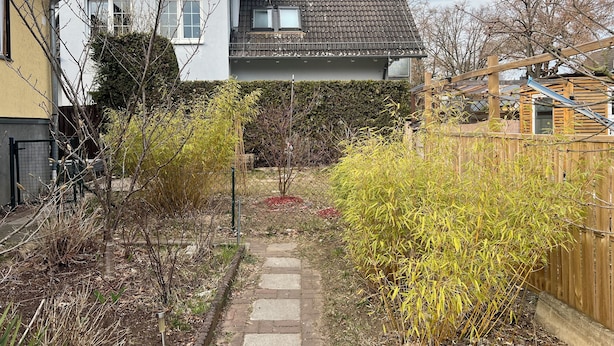 Il s’agit d’une propriété résidentielle dotée d’un chemin pavé, d’une clôture en bois et d’une grande variété de plantes.
