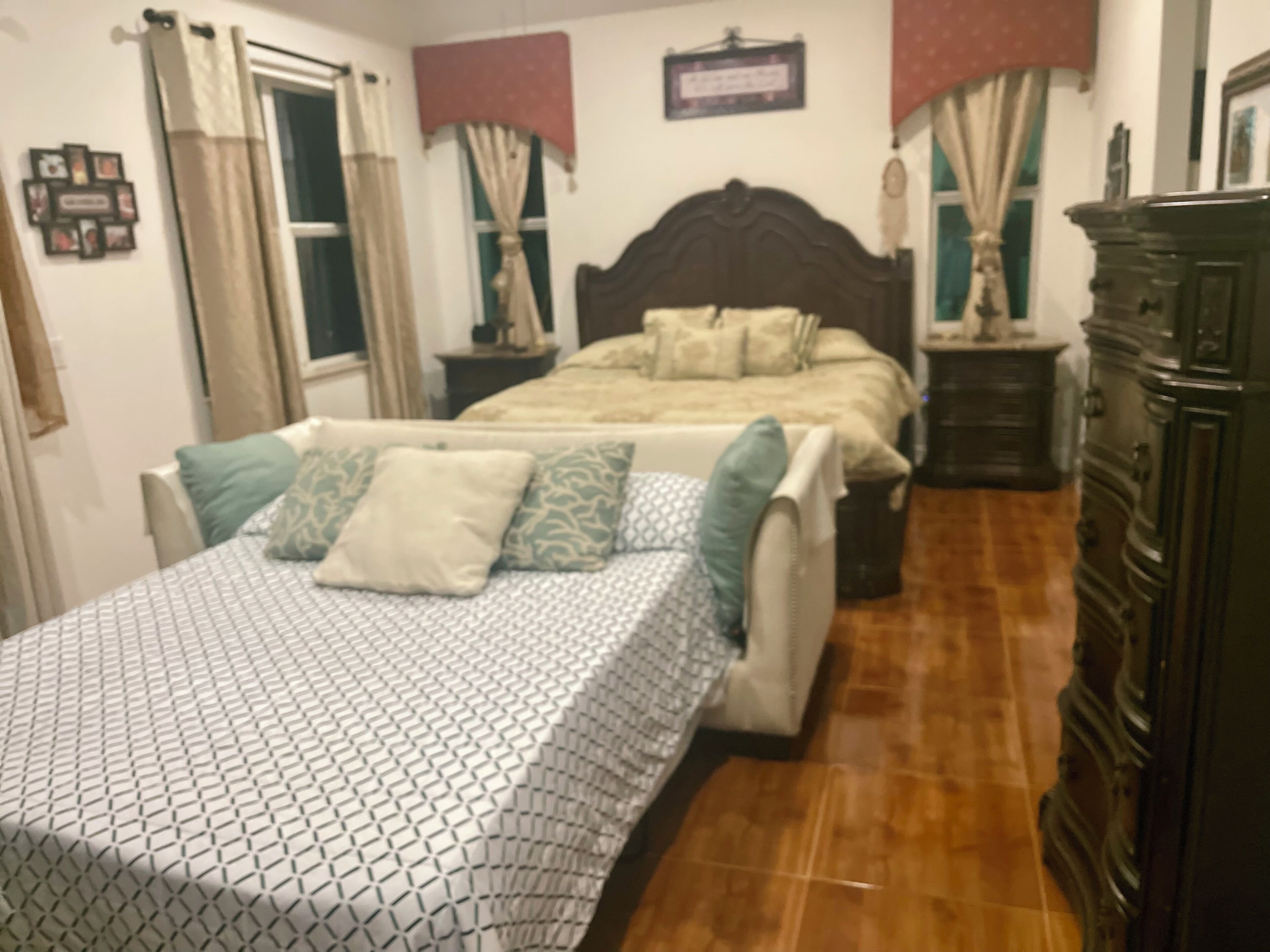 Une chambre à coucher avec un lit, une commode et une table de chevet.