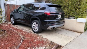 A black GMC Yukon SUV parked in a driveway. - Spacious 5BR Home 5 min to Rodeo Drive with Hot Tub, Spacious Backyard & Parking (Beverly Hills)
