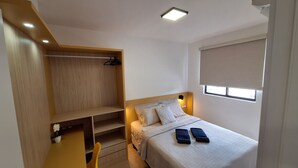 A bedroom with a bed, bedside table, and a built-in wardrobe.