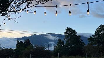 A scenic view with a mountain in the background, a string of lights, and a fence in the foreground.