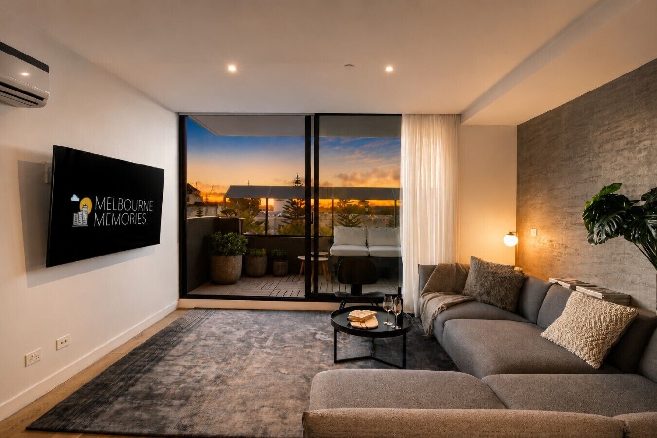 Uma sala de estar moderna com um sofá, uma mesa de centro e uma TV fixada na parede.