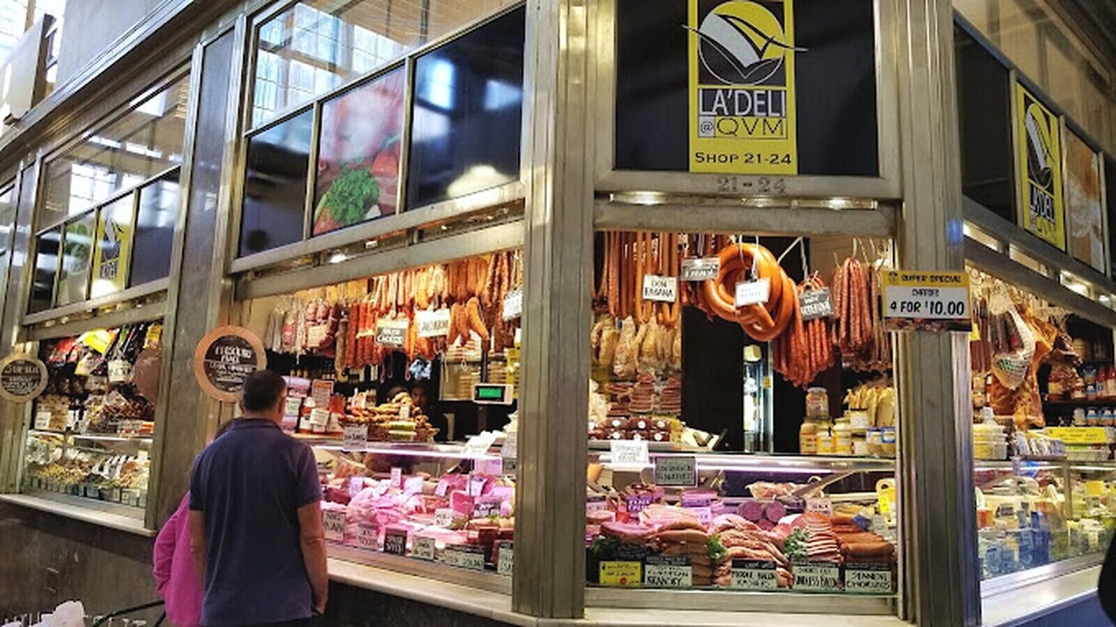 Un puesto de mercado con diversas carnes y quesos a la vista.