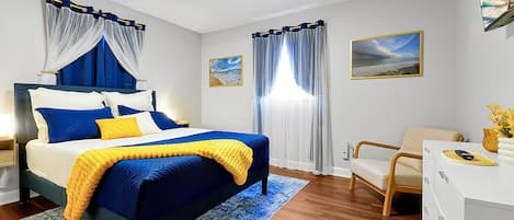 Ein Schlafzimmer mit einem Bett, einem Schreibtisch, einem Stuhl und zwei Bildern an der Wand.