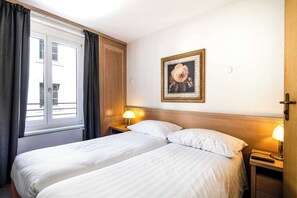 A hotel room with two beds, a window with curtains, a wall-mounted picture, and bedside lamps. - Apartment Cosy -1BR-4P- Genève (Genève)