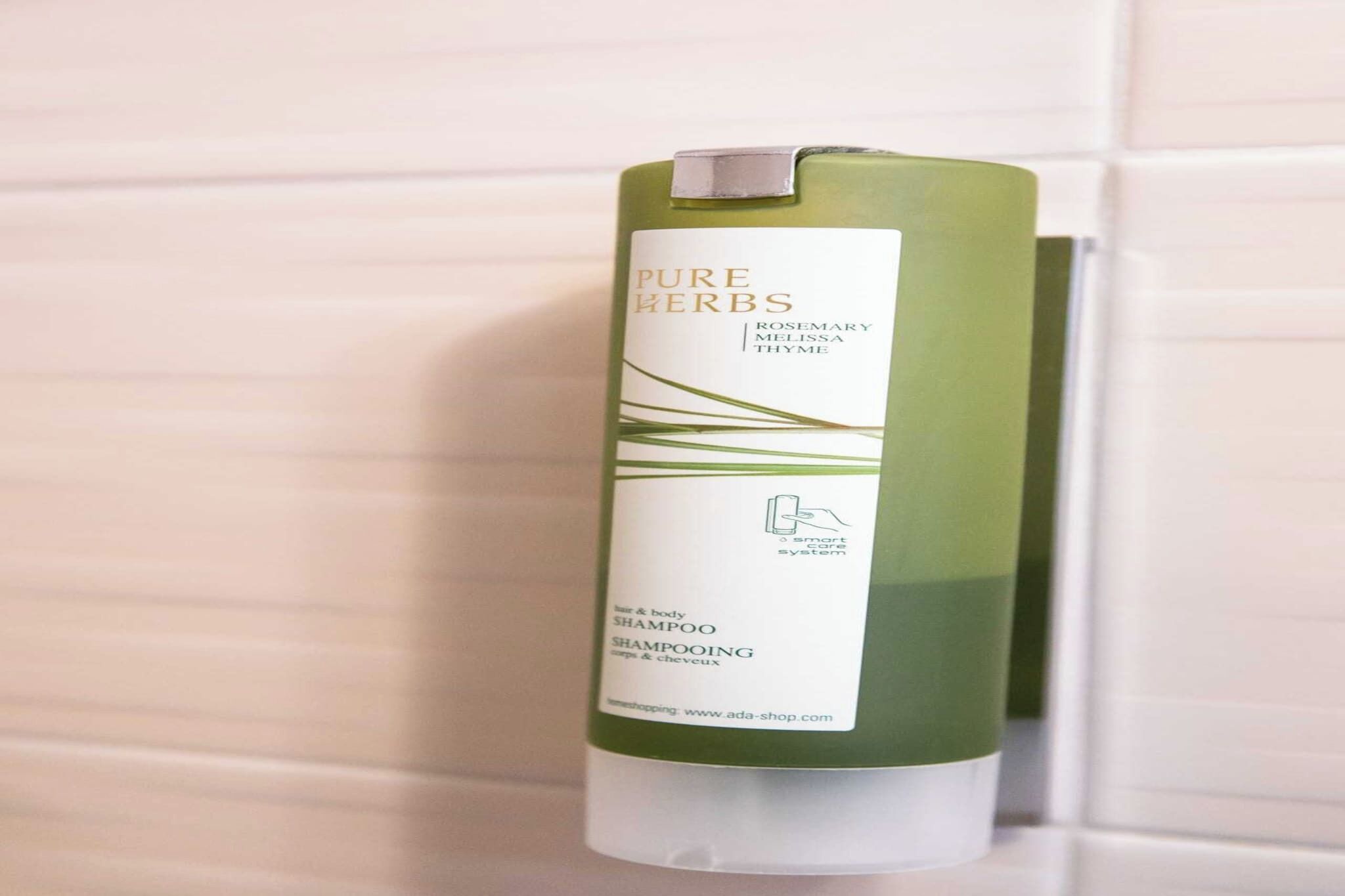 Een fles Pure Herbs shampoo met rozemarijn, citroenzest en tijm.