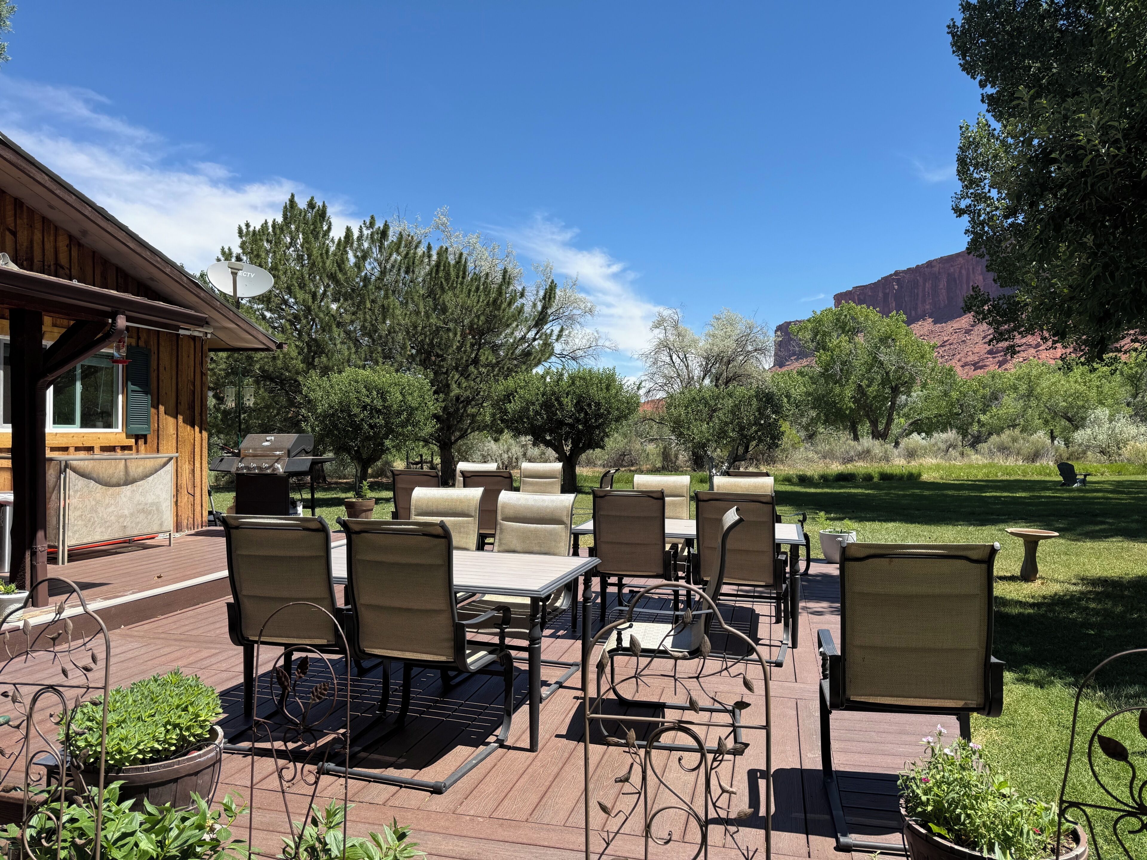 An outdoor patio with a wooden deck, outdoor furniture, and a view of the surrounding landscape.