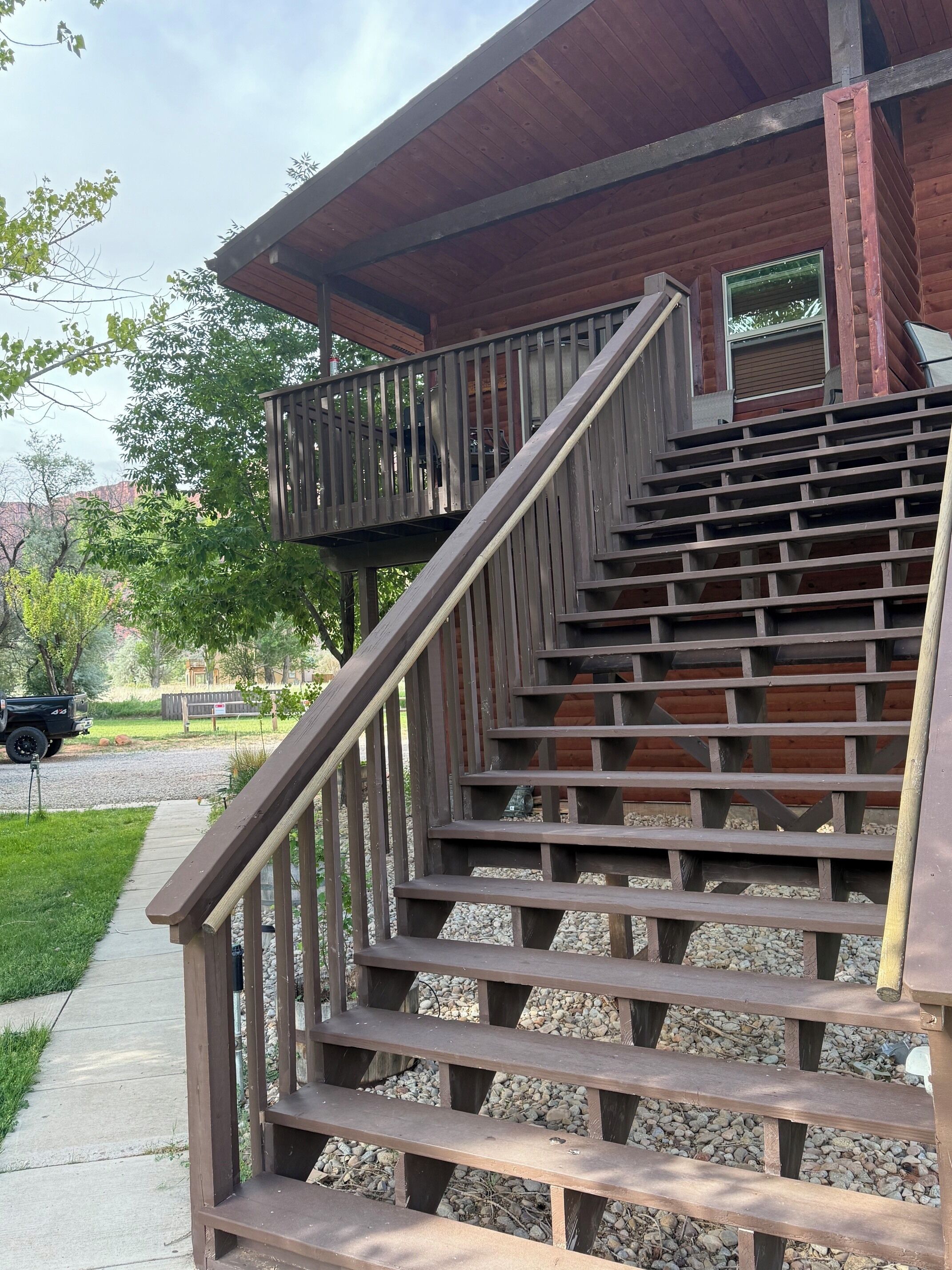 A wooden staircase leading to a covered area with a view of a residential street.
