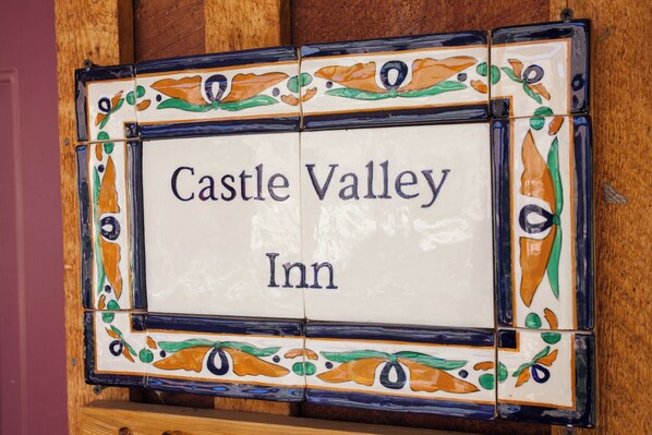 A sign with 'Castle Valley Inn' written on it, surrounded by decorative tiles.