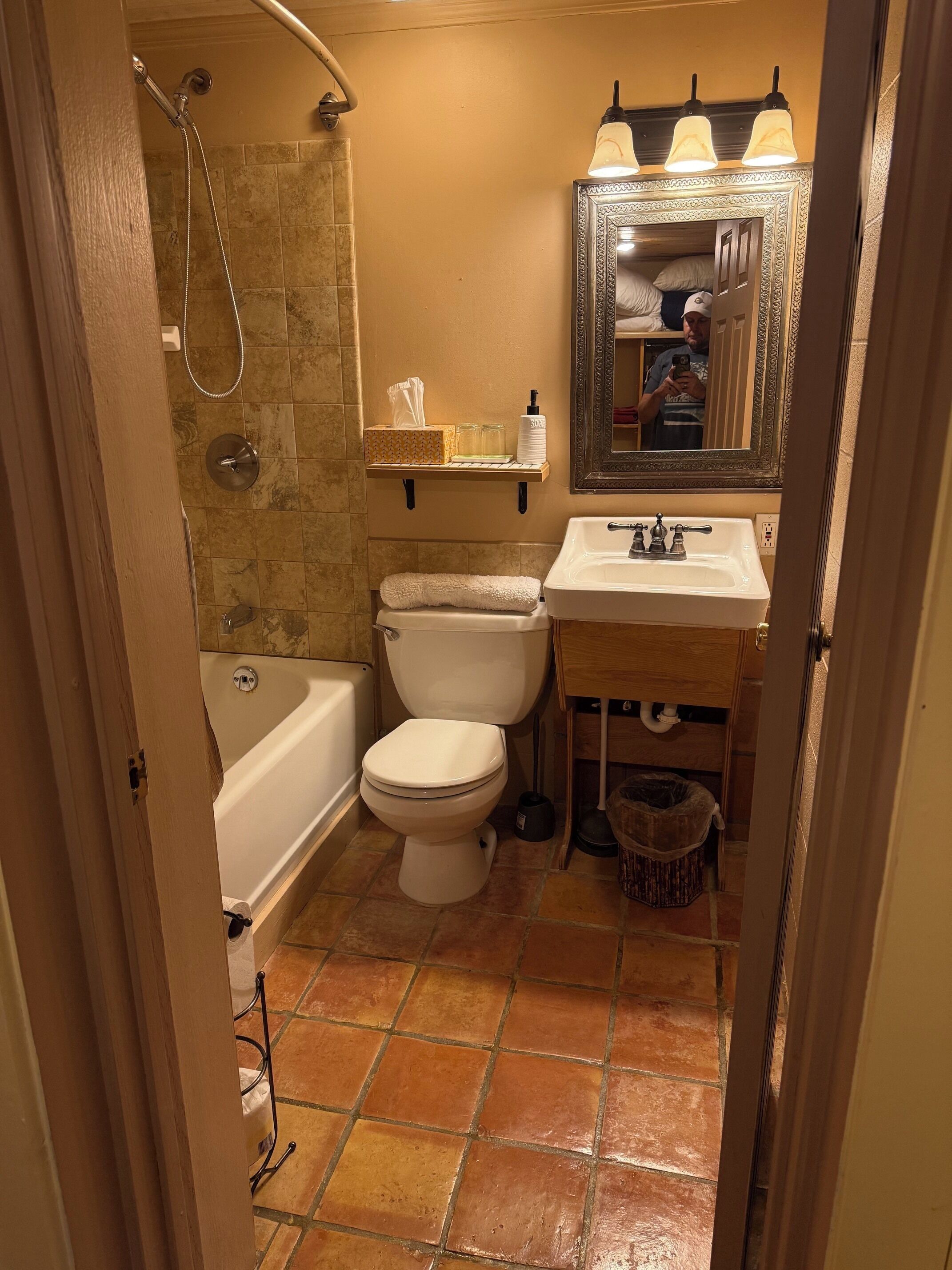 Une salle de bain équipée d’une baignoire, de toilettes, d’un lavabo et d’un miroir avec éclairage.