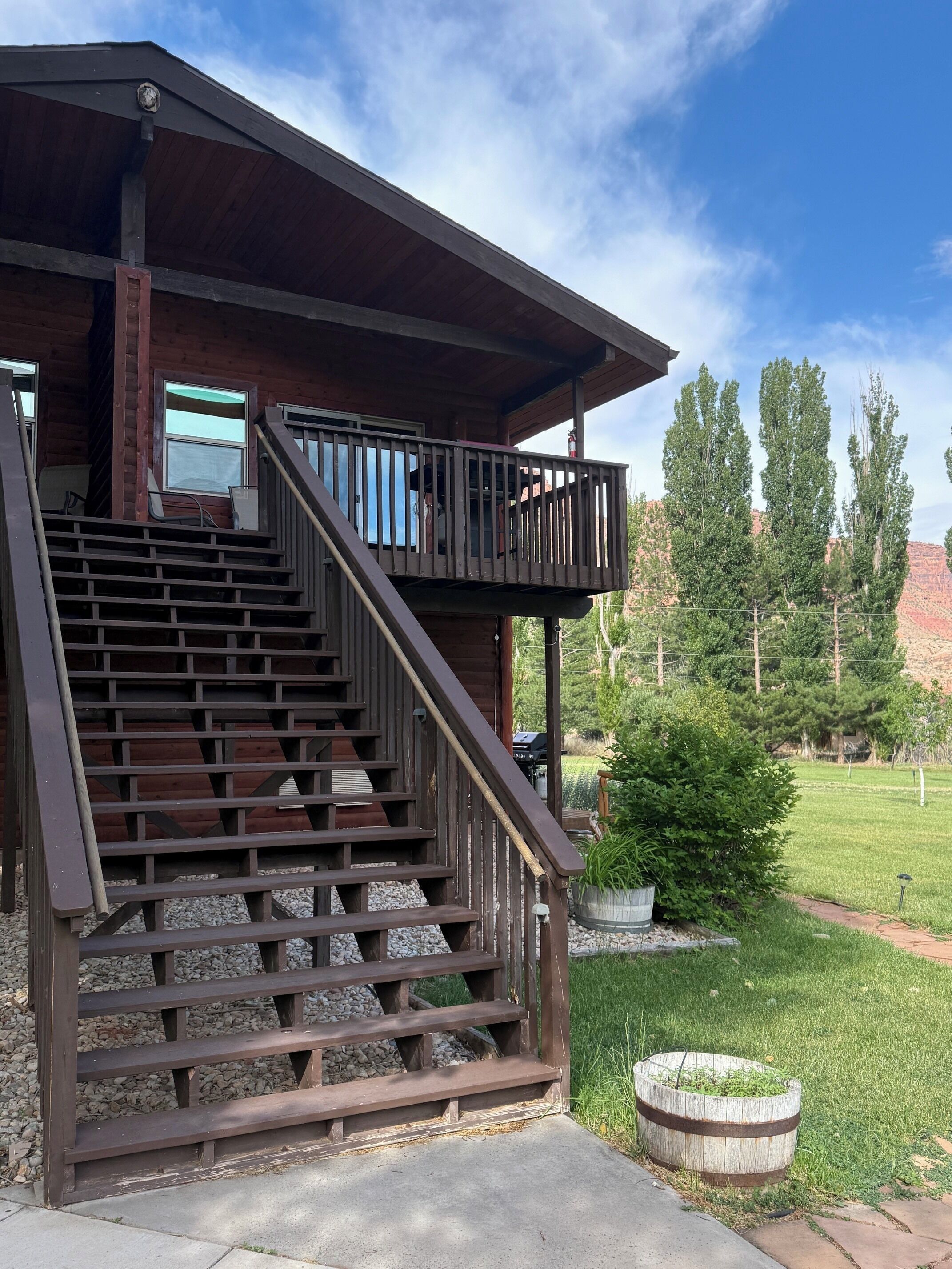 A wooden staircase leading to a covered porch with a railing.