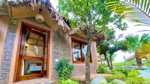A two-story building with a brick facade and wooden doors. - Lemon Tree Homestay Tam Coc (Nam Hoa Lu)