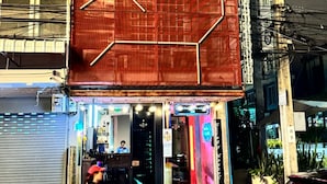A building with a large, red, geometric facade. - Stingy Hostel (Bangkok)