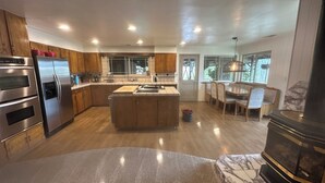 Una cocina moderna con electrodomésticos integrados, una isla central y un comedor con luz natural.