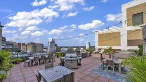 Une terrasse sur le toit avec des sièges extérieurs, un barbecue et une vue sur le paysage urbain.