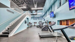 Un centre de remise en forme équipé de tapis de course, d’appareils de musculation et d’un escalier.
