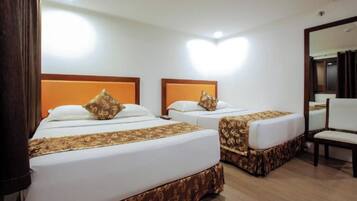 Two single beds with matching headboards and footboards, a wooden floor, and a mirror on the wall.