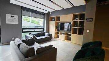 Business Apartment | Living area | 50-inch flat-screen TV with satellite channels