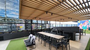 An outdoor dining area with a wooden ceiling, black chairs, and a table. - Despierta con vista a la montaña (Bogotá)