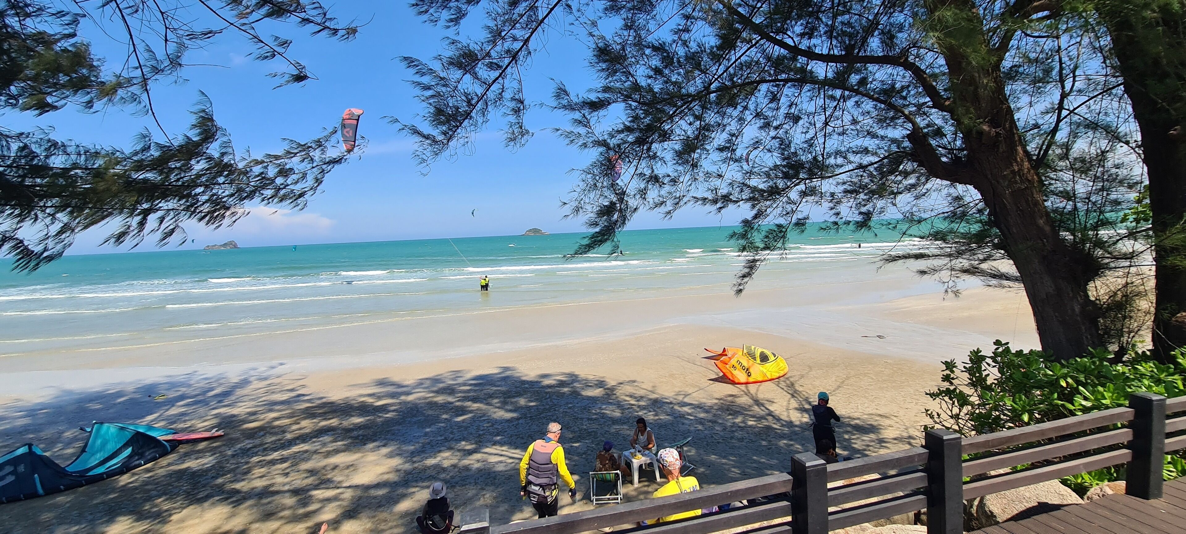 Ein Strand mit Menschen, einem Rettungsschwimmer und einem gelben Luftmatratze.