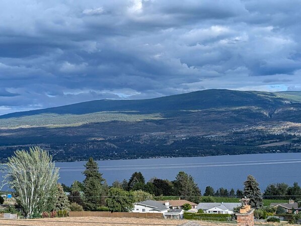 Zona residencial con casas, un lago y montañas al fondo.