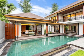A modern two-story house with a swimming pool, large windows, and a balcony. - Sewana Villa by Kozystay - Natadesa Resort (Jimbaran)
