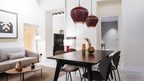 Een moderne woonkamer met een eethoek, met een bank, salontafel en een eettafel met stoelen.