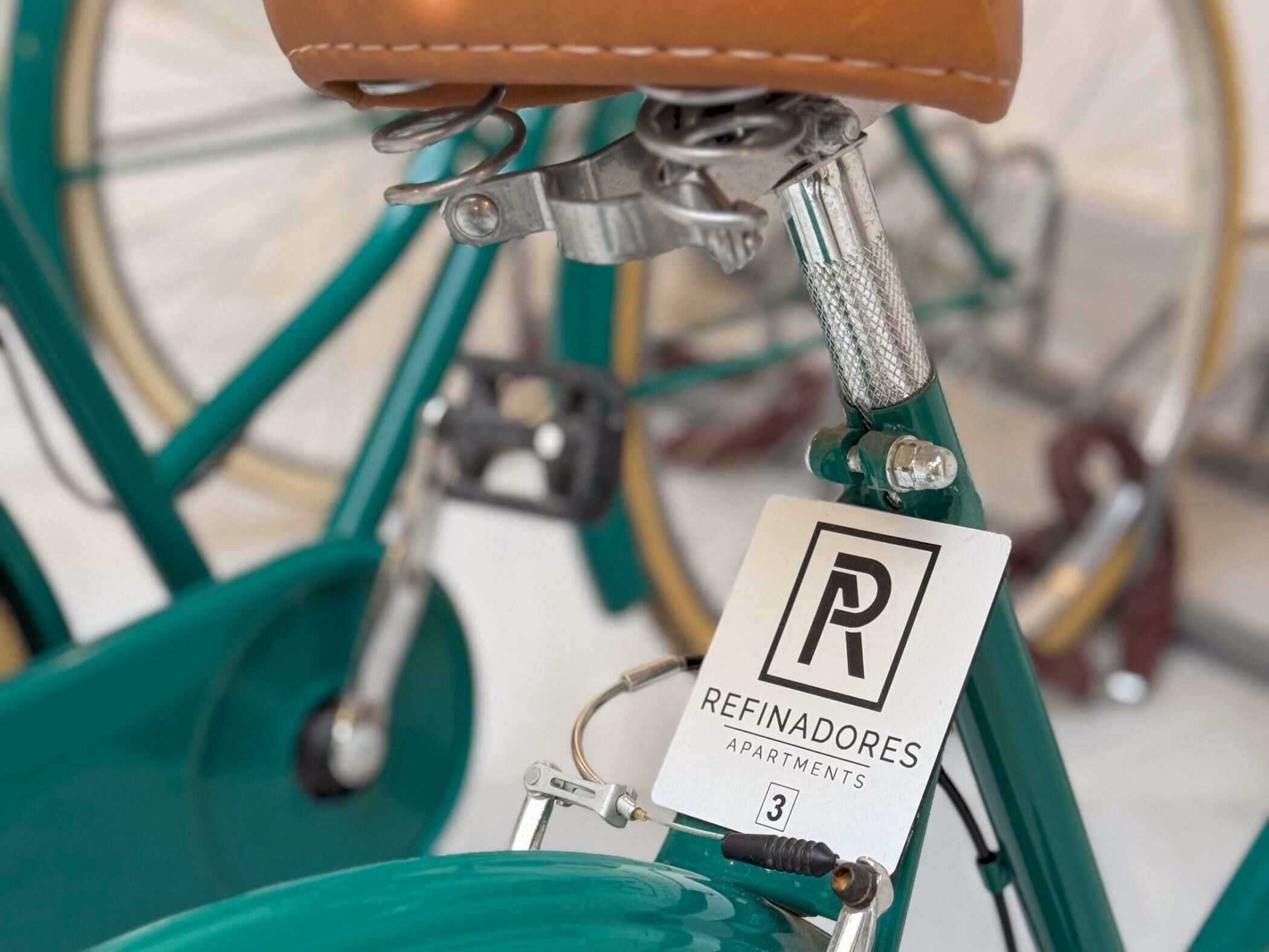 Gros plan d’un vélo vert sur lequel est apposée une étiquette indiquant « Refinadores Apartamentos 3 ».