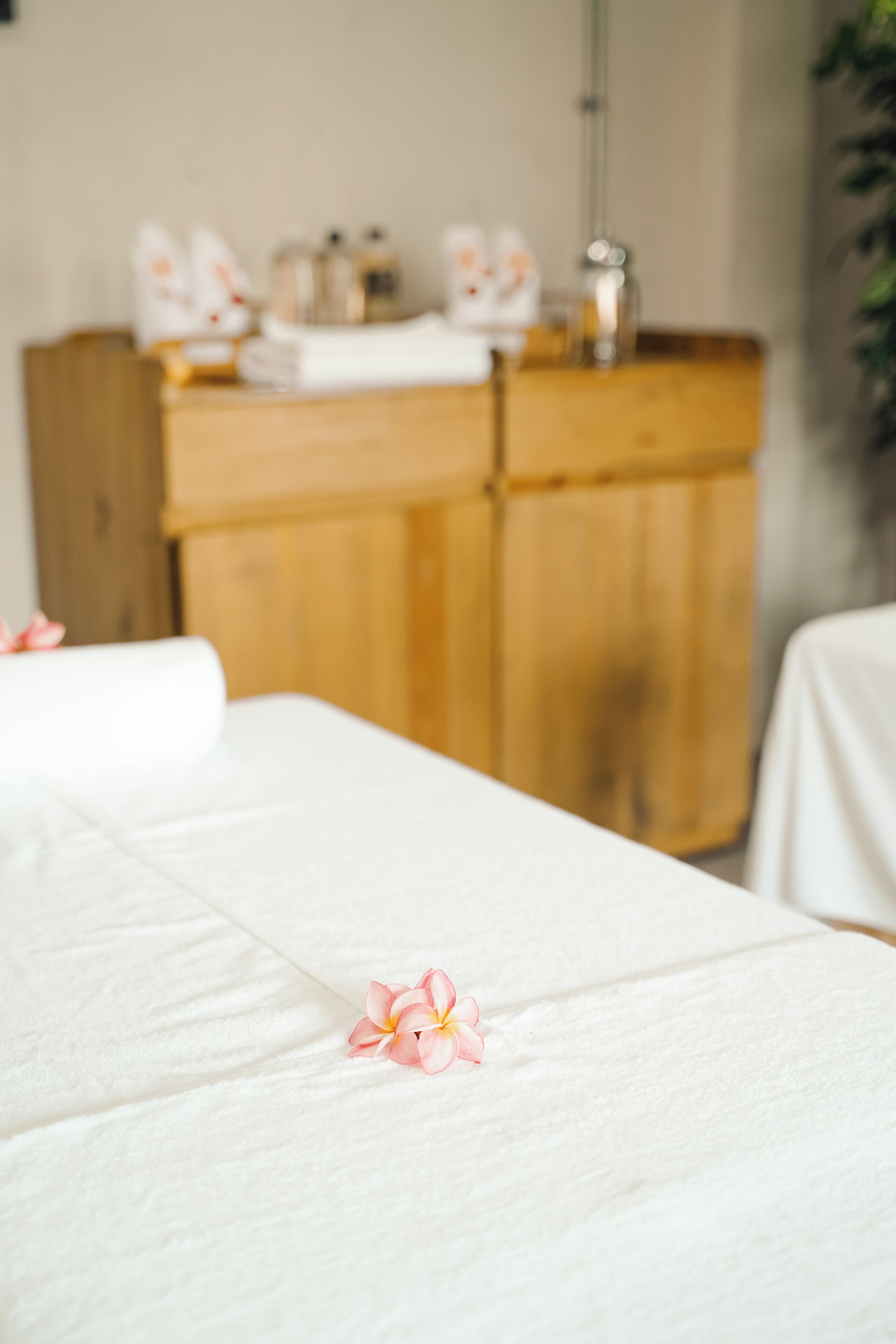 Un cuarto de spa con un armario de madera al fondo y una toalla blanca sobre una cama.