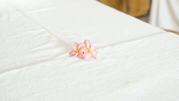 Un cuarto de spa con un armario de madera al fondo y una toalla blanca sobre una cama.