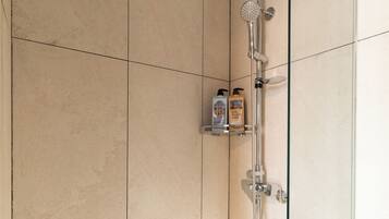 A modern shower with a handheld showerhead and a fixed rain showerhead.