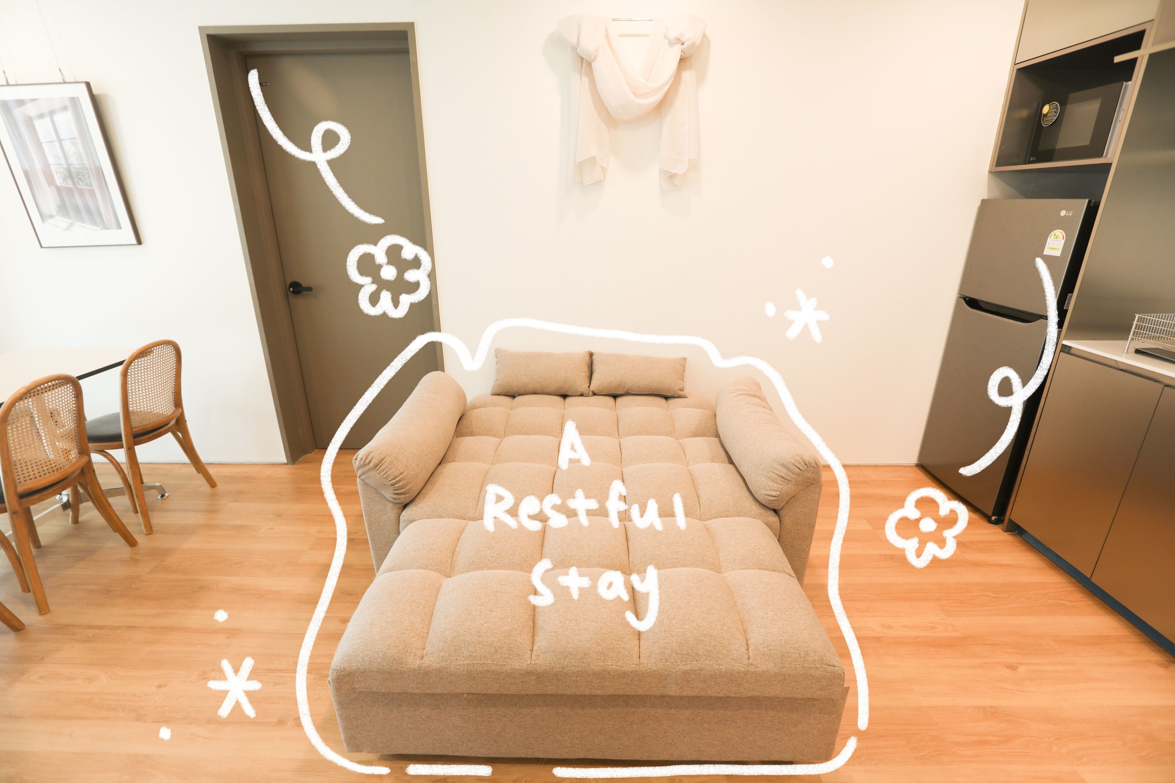 Una habitación con sofá, una silla, una puerta y un refrigerador.